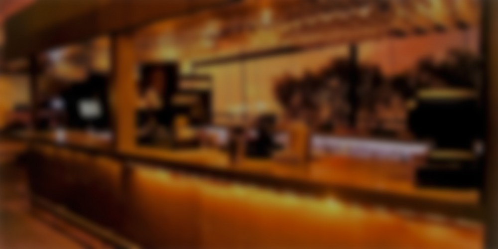 Layered paper cut-out collage in amber, gold, and deep charcoal tones evoking a warm bar counter at dusk.